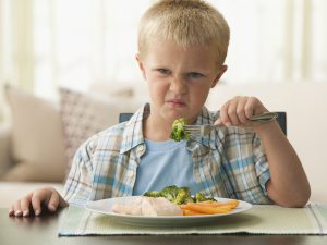 keep calm and eat your veggies com uma criança com expressão ruim ao ter que comer vegetais