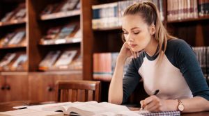Inglês para iniciantes moça estudando em uma biblioteca
